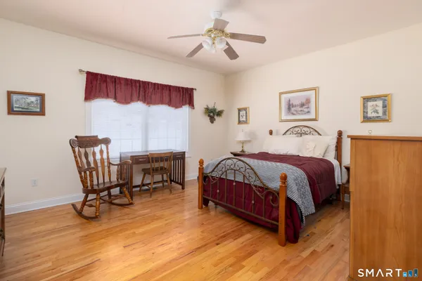 a spacious bedroom with a bed a table and chair