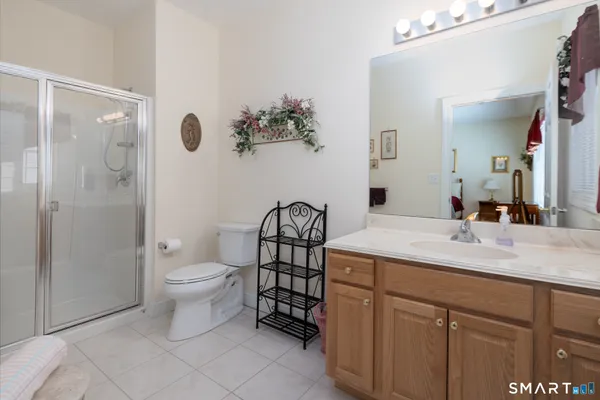 a bathroom with a granite countertop toilet a sink and a mirror
