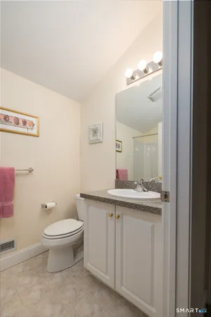 a bathroom with a toilet a sink and mirror