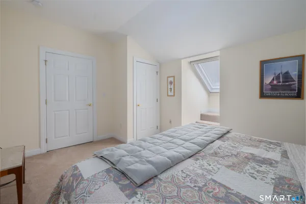 a bedroom with a bed and a painting on the wall