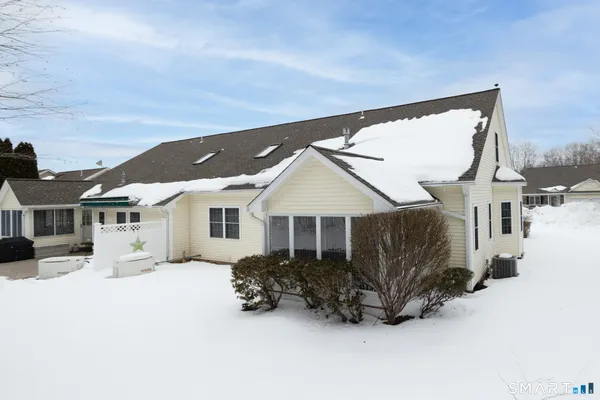 a view of a house with a yard covered in snow