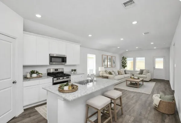 a kitchen with sink refrigerator stove dining table and chairs