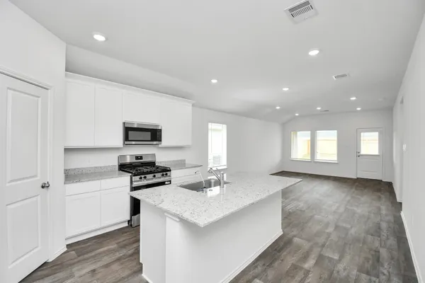 a kitchen with a sink stainless steel appliances and white cabinets