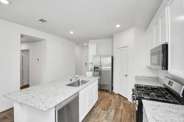 a kitchen with stainless steel appliances granite countertop a sink stove and refrigerator