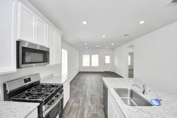 a kitchen with a sink a stove and cabinets