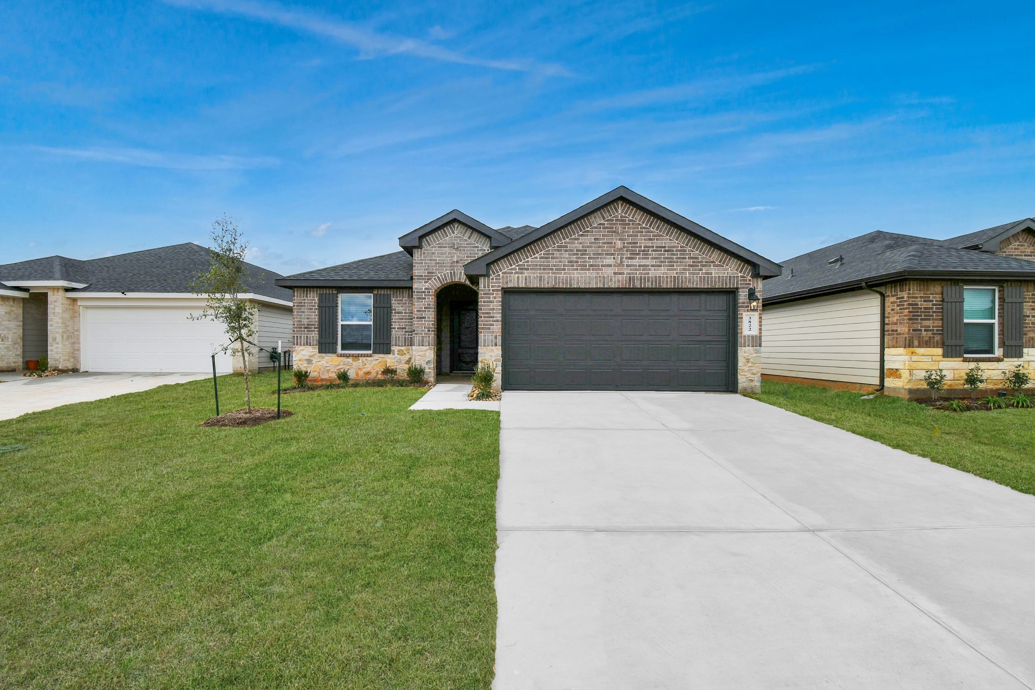 3822 Zoeys Way Fulshear, TX 77423 - Photo 5 of 37 a front view of a house with a garden and yard