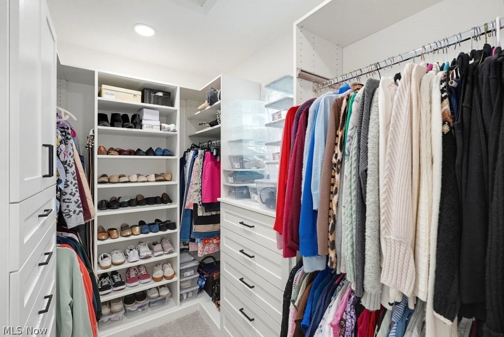 851 Susan Road Ravenna, OH 44266 - Photo 33 of 50 Built-in closet system featuring white shelving, multiple hanging rods, white drawers with black hardware, and recessed lighting