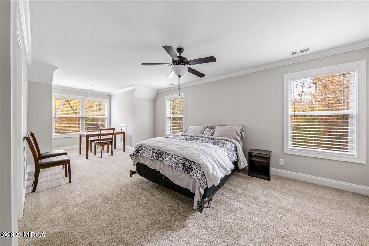 208 Carters Way Forsyth, GA 31029 - Photo 17 of 22 a spacious bedroom with a bed a chandelier and a larger window