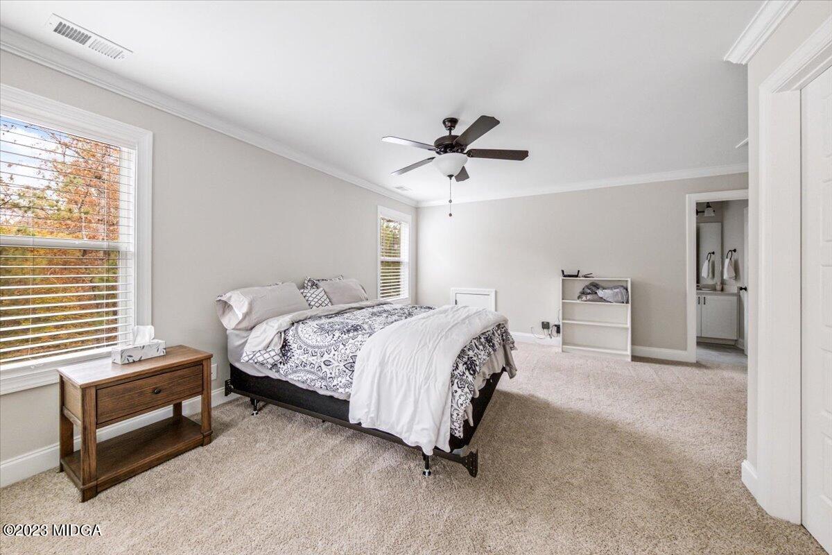 208 Carters Way Forsyth, GA 31029 - Photo 18 of 22 a spacious bedroom with a bed and a chandelier