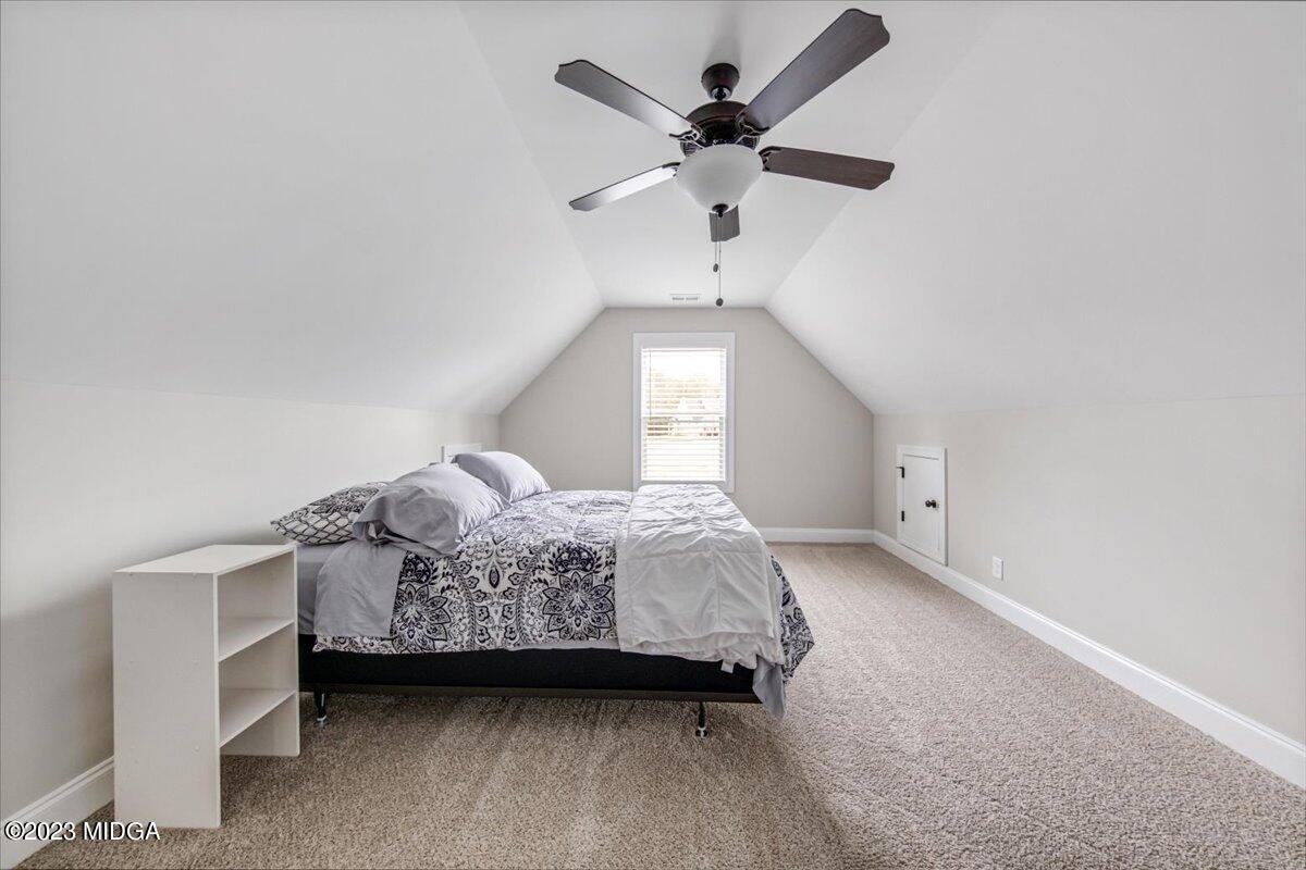208 Carters Way Forsyth, GA 31029 - Photo 19 of 22 a bedroom with a bed chandelier and a window
