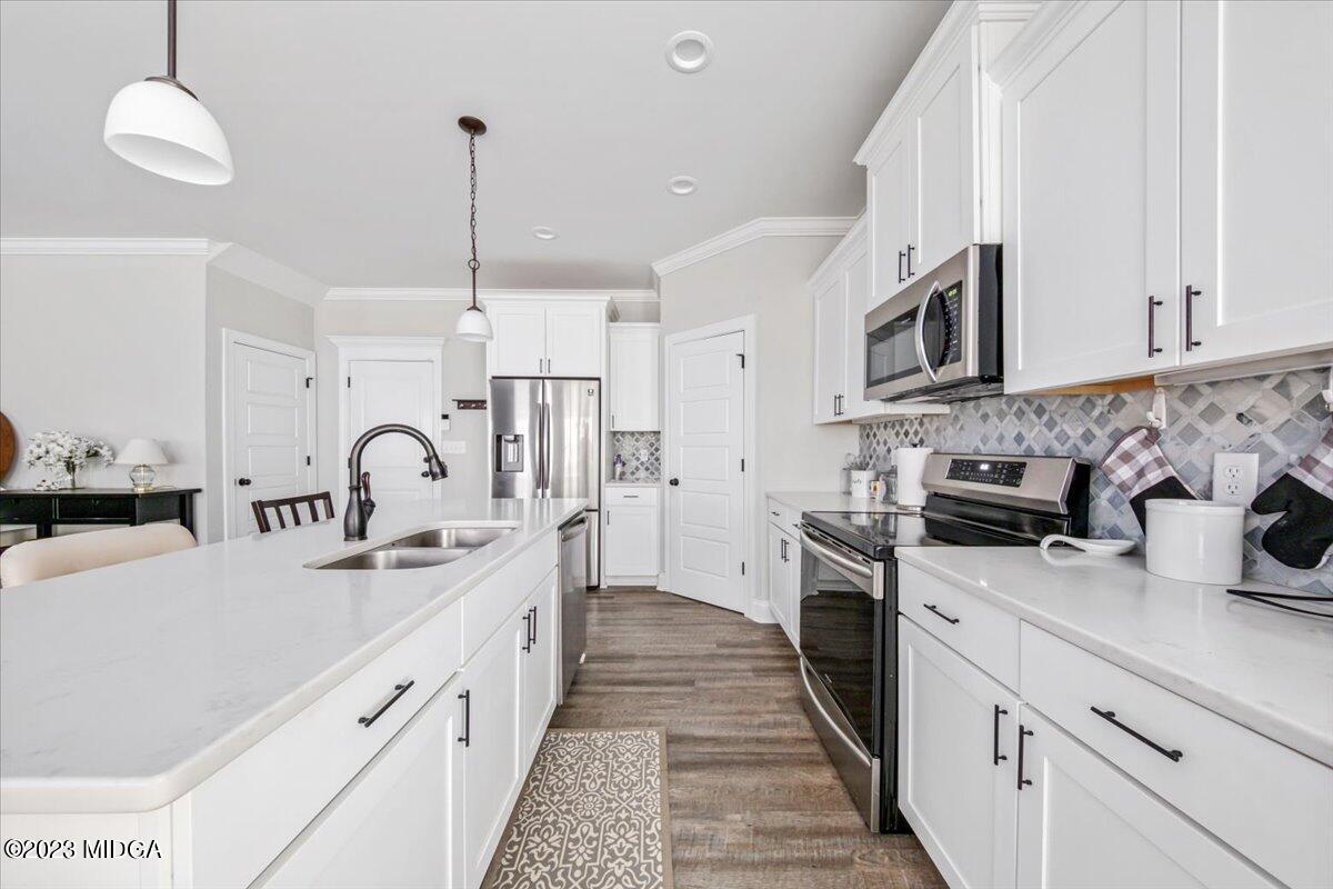 208 Carters Way Forsyth, GA 31029 - Photo 7 of 22 a kitchen with stainless steel appliances granite countertop a sink a stove and a refrigerator