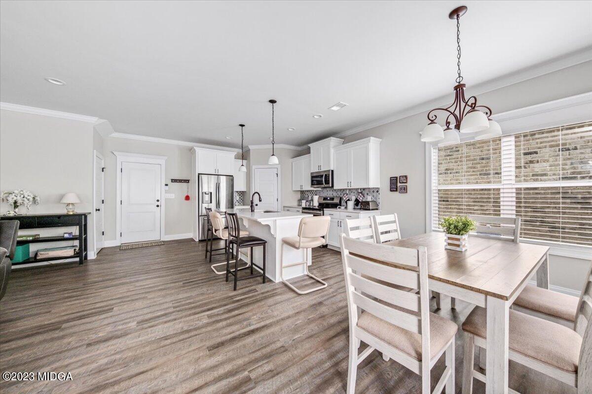 208 Carters Way Forsyth, GA 31029 - Photo 9 of 22 a kitchen with stainless steel appliances a dining table chairs stove and refrigerator