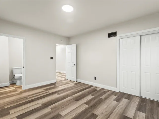 a view of a room with wooden floor and white walls