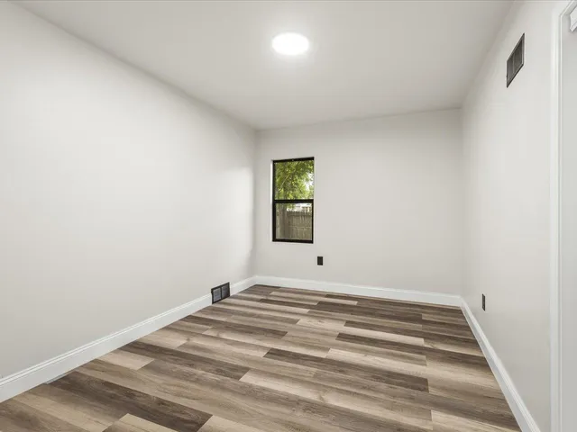 a view of a room with wooden floor and window