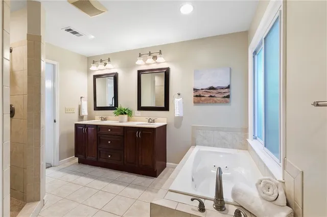 a bathroom with a tub sink and mirror