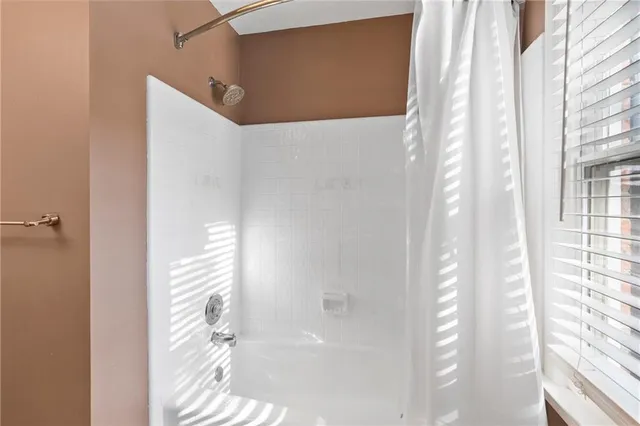 a bathroom with a shower and a window
