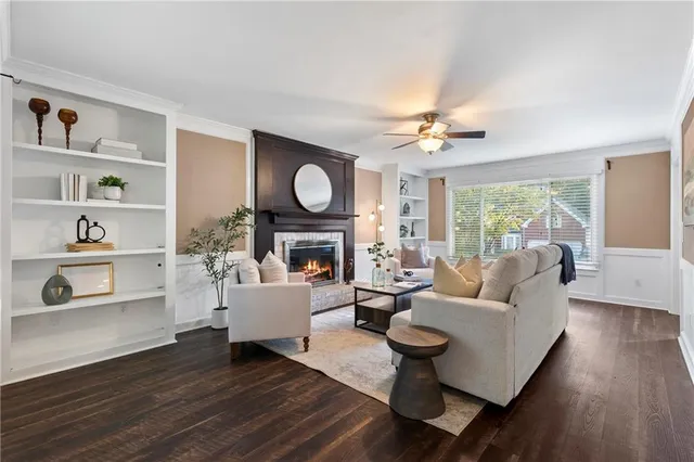 a living room with furniture a fireplace and a large window