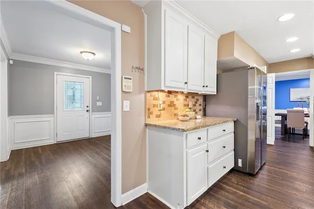 a kitchen with granite countertop wooden floors and white cabinets
