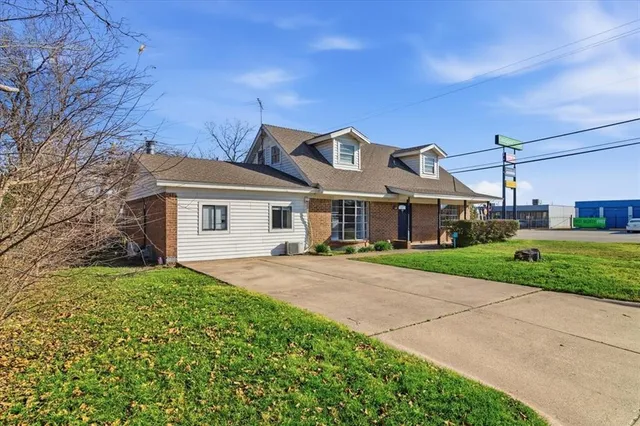 a front view of a house with a garden and yard