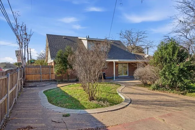 a view of a house with a small yard and potted plants