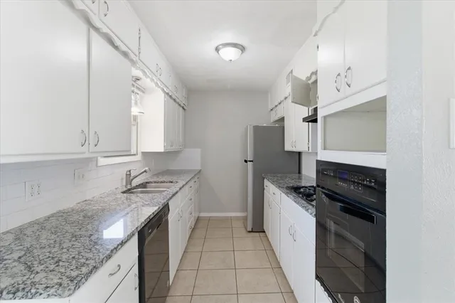 a kitchen with a sink stove top oven and cabinets