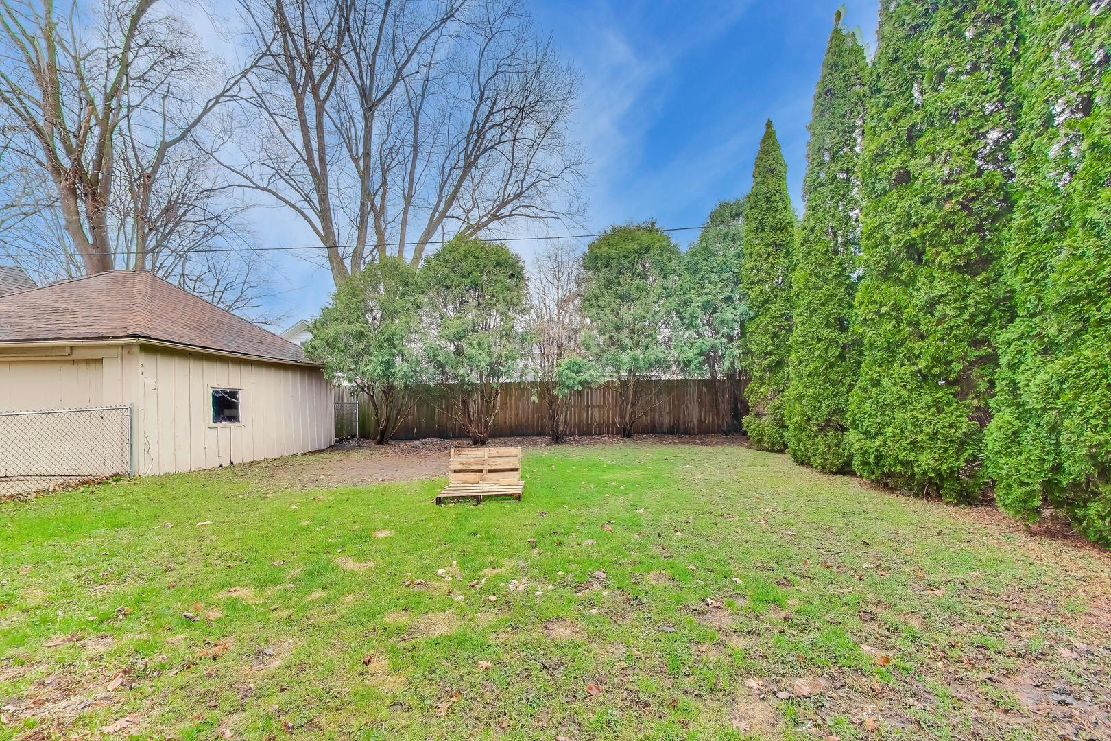 405 West Brown Street Harvard, IL 60033 - Photo 16 of 24 a backyard of a house with plants and tree