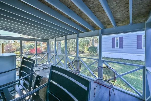 a view of a balcony with chairs and wooden fence