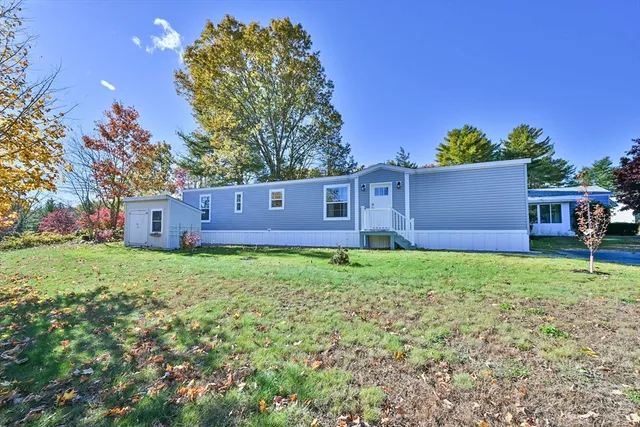 a view of a backyard with potted plants and large trees