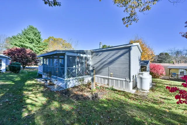 a backyard of a house with wooden fence and large trees