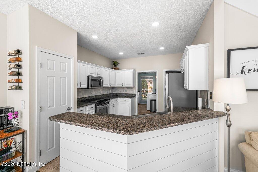 3734 Reedpond Drive North Jacksonville, FL 32223 - Photo 19 of 55 a kitchen with stainless steel appliances granite countertop a sink and a refrigerator