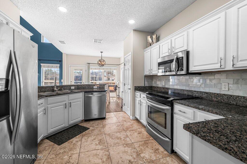 3734 Reedpond Drive North Jacksonville, FL 32223 - Photo 22 of 55 a kitchen with stainless steel appliances granite countertop a stove a sink and a refrigerator