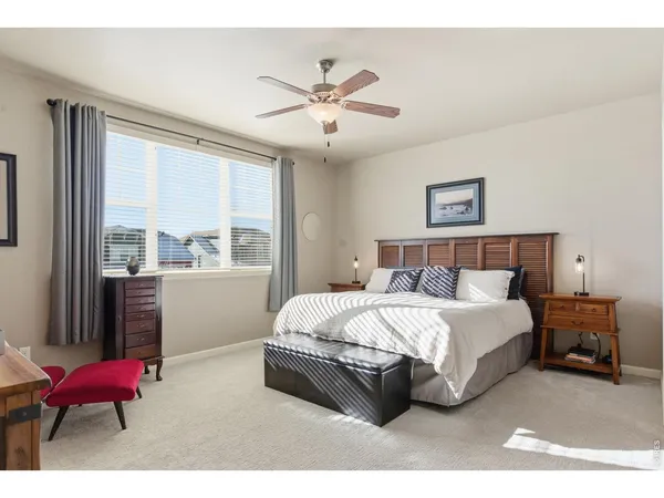 a spacious bedroom with a bed mirror and window
