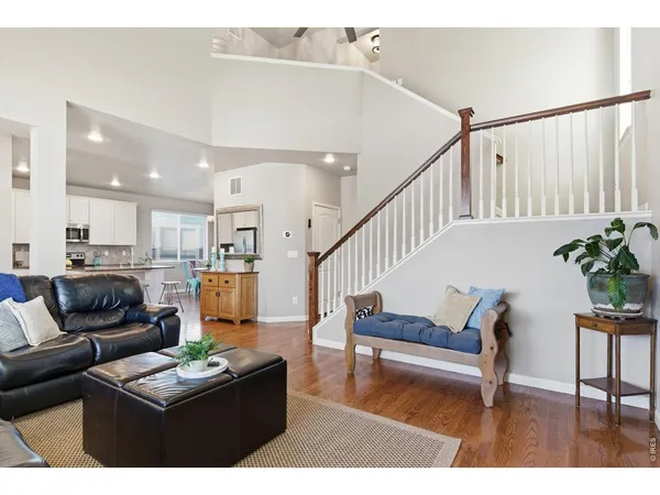a living room with furniture and a dining table with wooden floor