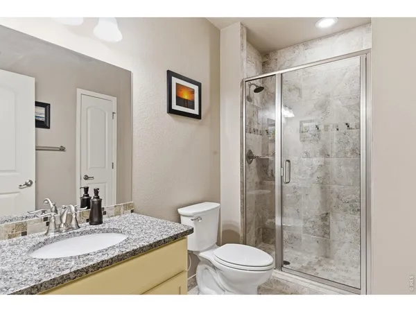 a bathroom with a granite countertop sink toilet and shower