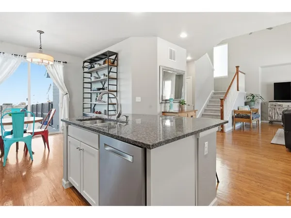 a kitchen with stainless steel appliances granite countertop a table chairs and a stove