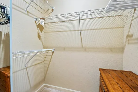 a view of walk in closet with clothes