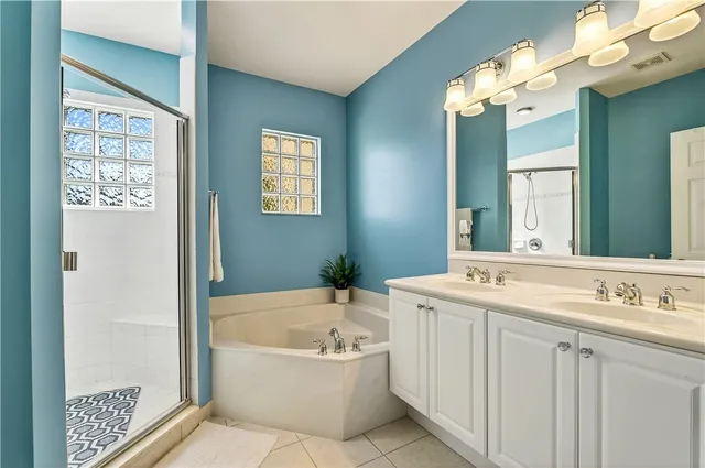 a bathroom with a tub a sink and a mirror
