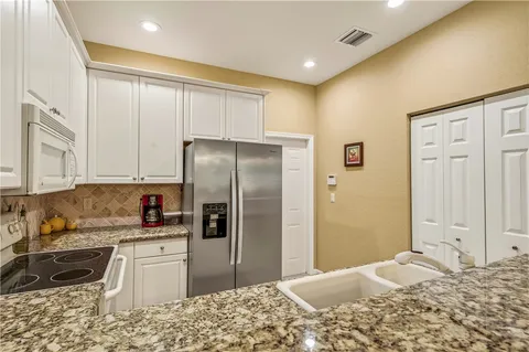 a kitchen with a refrigerator sink and cabinets