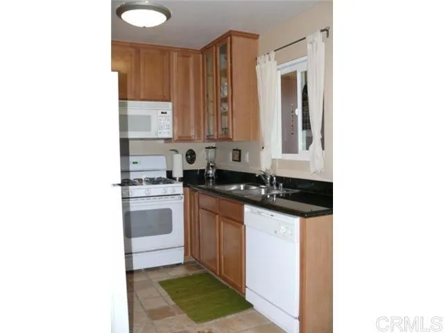 a kitchen with granite countertop a sink and a stove