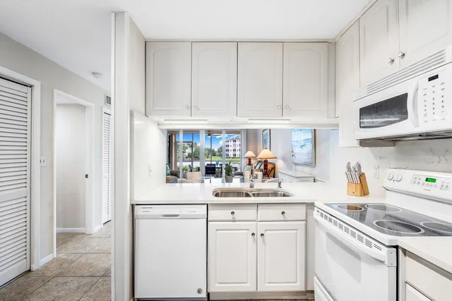 a kitchen with white cabinets and white appliances