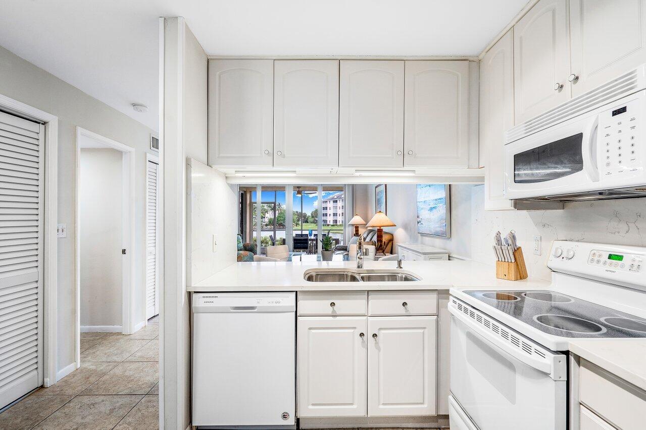 353 Highway 1, Unit F109 Jupiter, FL 33477 - Photo 11 of 22 a kitchen with white cabinets and white appliances