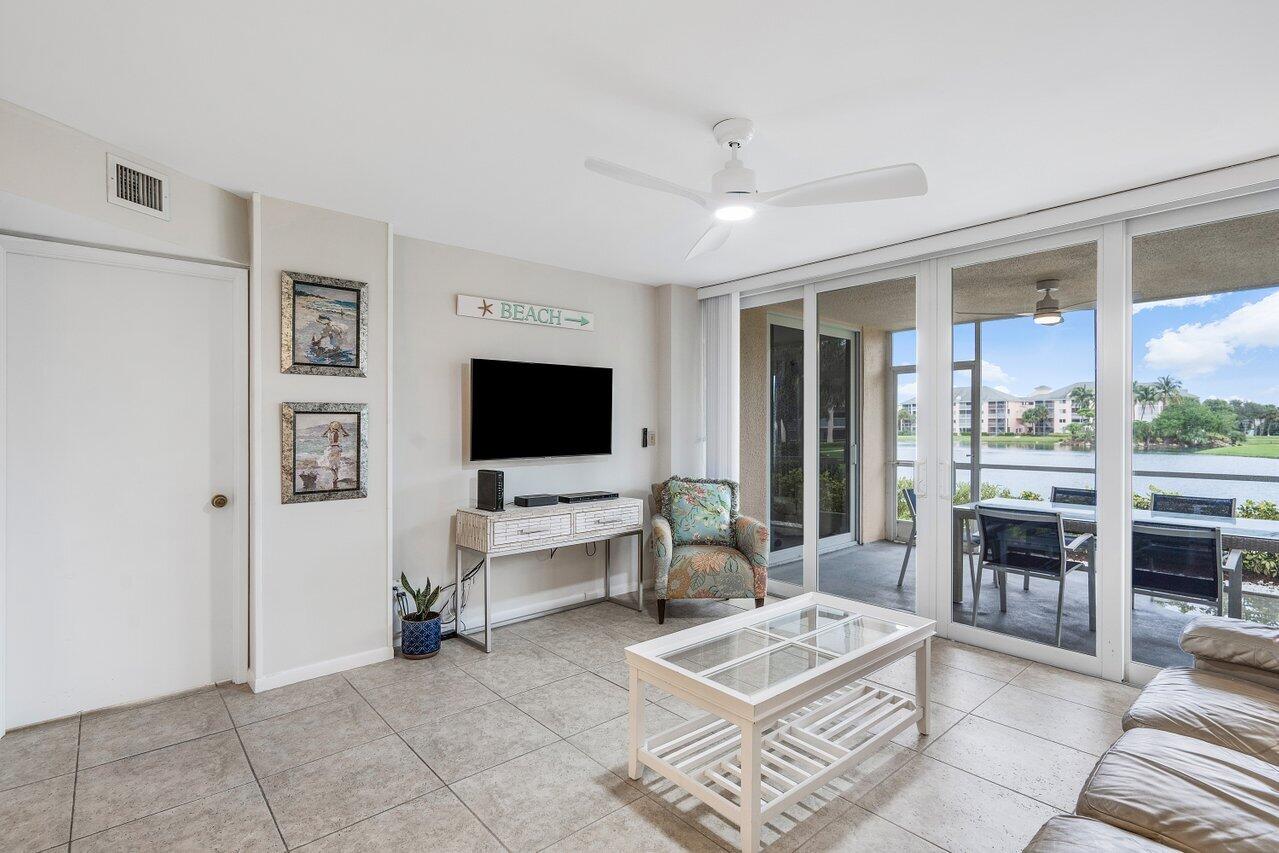 353 Highway 1, Unit F109 Jupiter, FL 33477 - Photo 7 of 22 a living room with furniture a flat screen tv and a floor to ceiling window