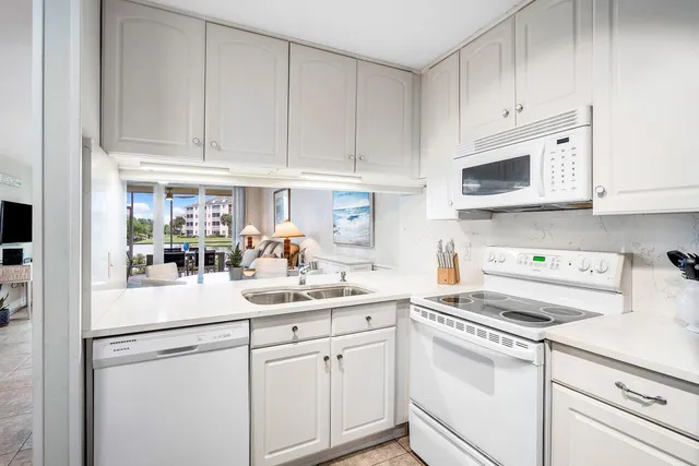 a kitchen with white cabinets and white appliances