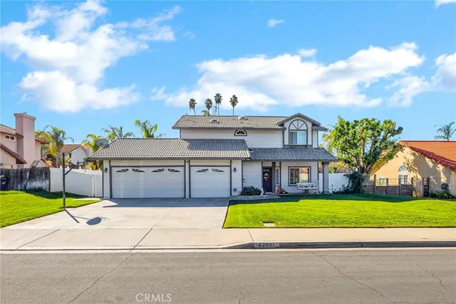 a view of a white house with a big yard and large trees