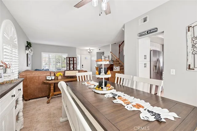 a view of a dining room and livingroom with furniture a rug a fireplace and wooden floor