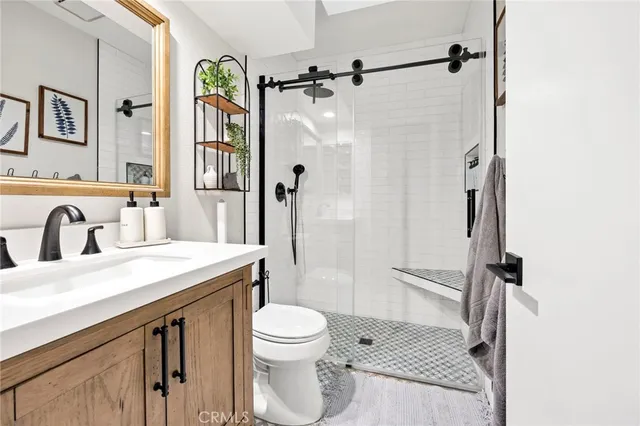 a bathroom with a granite countertop sink toilet and shower