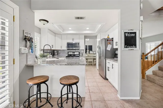 a kitchen with stainless steel appliances kitchen island granite countertop a refrigerator and a stove top oven