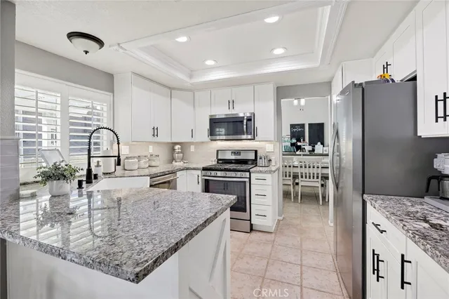 a kitchen with granite countertop a sink a counter top space appliances and cabinets