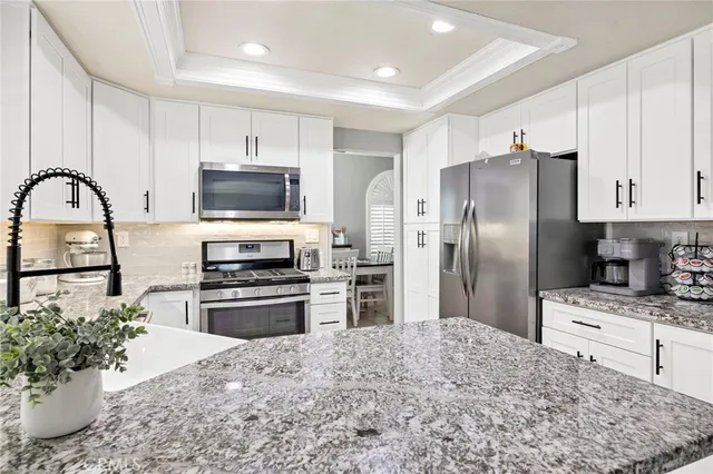 a kitchen with stainless steel appliances kitchen island granite countertop a refrigerator stove top oven and sink