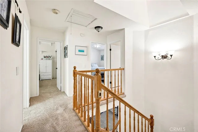 a view of a hallway with wooden floor and windows